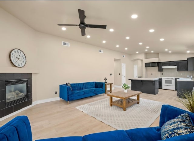 1656 N Cecelia Ave, Fresno, CA 93722 - living room with baseboards, ceiling fan, light wood-type flooring, recessed lighting, and a fireplace