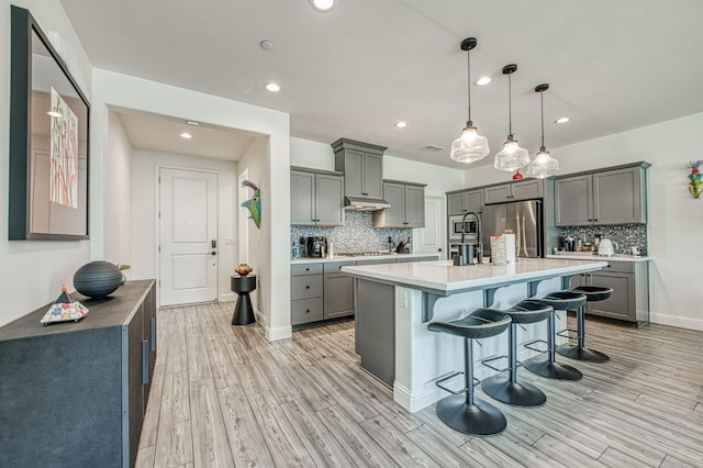 4148 Beverly Ave, Clovis, CA 93619 - kitchen with gray cabinetry, stainless steel appliances, light wood-style floors, tasteful backsplash, and recessed lighting