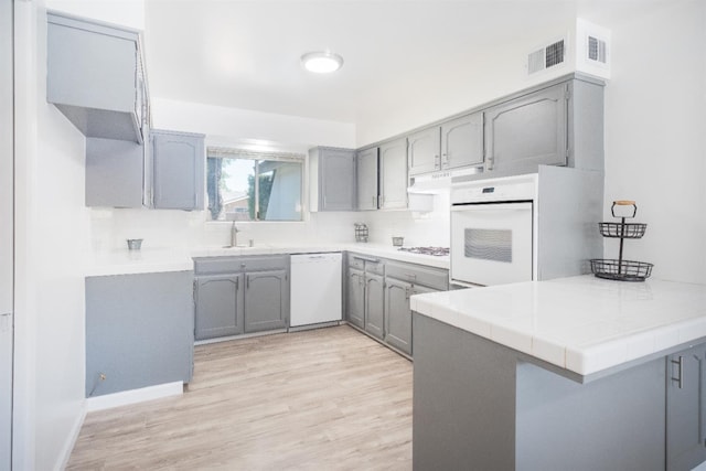1617 W Indianapolis Ave, Fresno, CA 93705 - kitchen with white appliances, gray cabinetry, a peninsula, and light wood finished floors