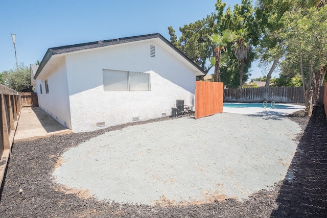 1617 W Indianapolis Ave, Fresno, CA 93705 - view of home's exterior with crawl space, a fenced backyard, stucco siding, and a patio