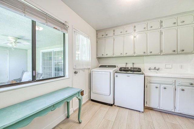 926 E Birch Ave, Fresno, CA 93720 - laundry area featuring cabinet space, washer and clothes dryer, ceiling fan, and light wood-style flooring