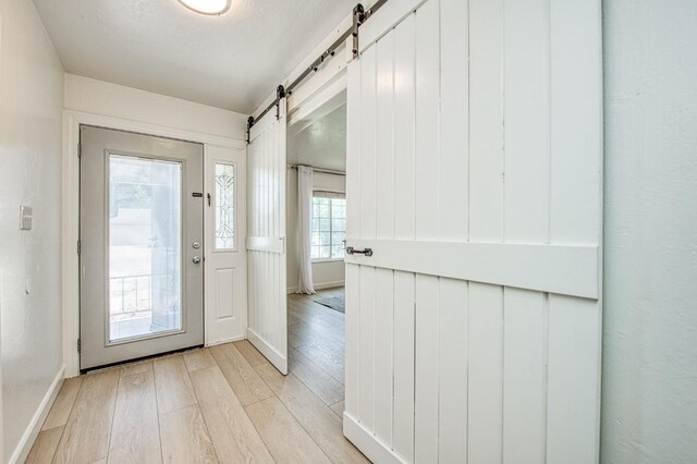 926 E Birch Ave, Fresno, CA 93720 - entryway featuring a barn door, light wood-style flooring, and baseboards