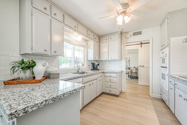 926 E Birch Ave, Fresno, CA 93720 - kitchen with a sink, a peninsula, light wood finished floors, ceiling fan, and tasteful backsplash