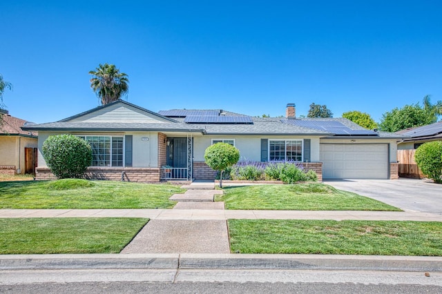 926 E Birch Ave, Fresno, CA 93720 - single story home featuring brick siding, a garage, solar panels, and concrete driveway