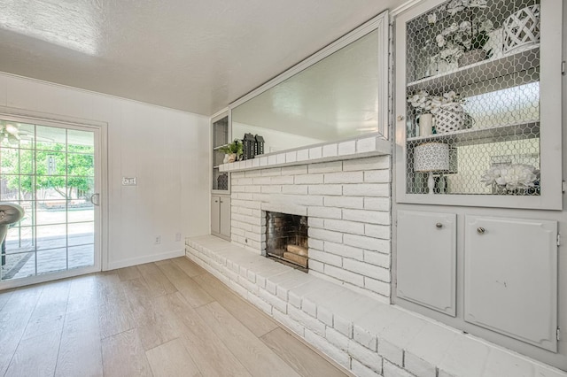 926 E Birch Ave, Fresno, CA 93720 - unfurnished living room featuring light wood finished floors, baseboards, and a brick fireplace