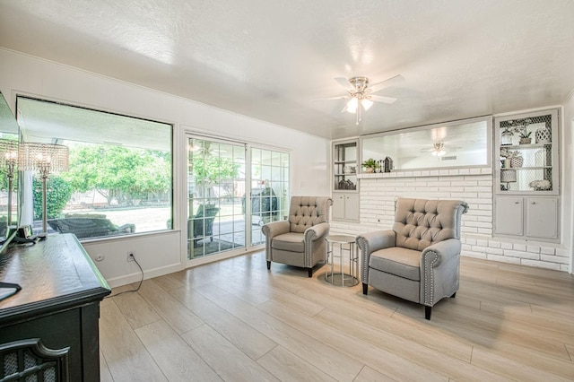 926 E Birch Ave, Fresno, CA 93720 - living area with a ceiling fan, light wood-style floors, built in features, baseboards, and a textured ceiling