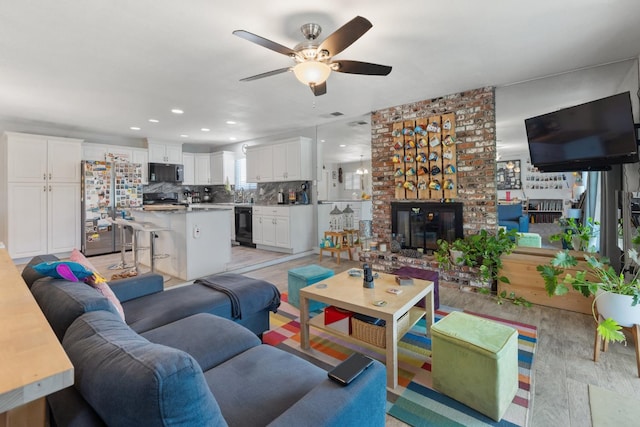 2141 Akers St, Visalia, CA 93277 - living room featuring a fireplace, a ceiling fan, light wood finished floors, and recessed lighting