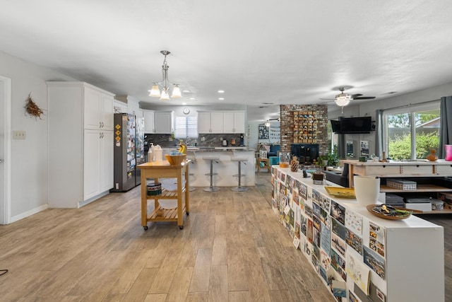 2141 Akers St, Visalia, CA 93277 - kitchen with freestanding refrigerator, open floor plan, ceiling fan, light wood-style flooring, and decorative backsplash