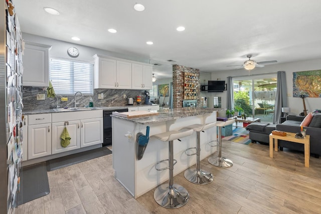 2141 Akers St, Visalia, CA 93277 - kitchen featuring black dishwasher, a sink, open floor plan, light wood-style floors, and healthy amount of natural light