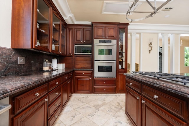 14215 Killarney Dr, Madera, CA 93636 - kitchen featuring stainless steel appliances, decorative backsplash, ornate columns, glass insert cabinets, and dark stone countertops
