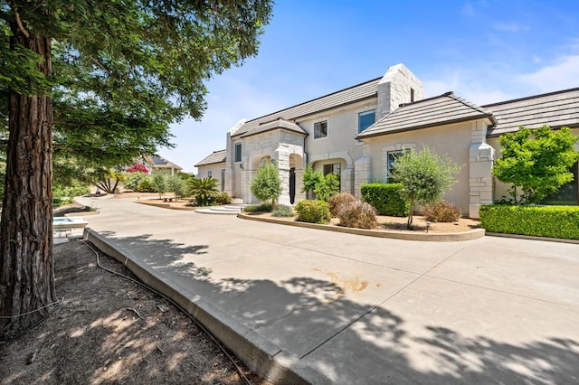 14215 Killarney Dr, Madera, CA 93636 - view of front of house with stone siding, stucco siding, and a chimney