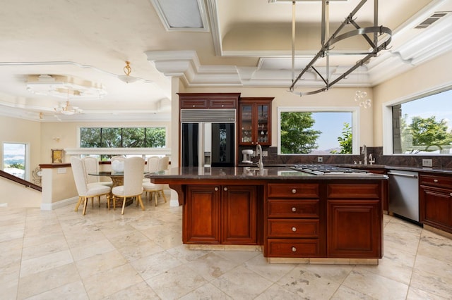 14215 Killarney Dr, Madera, CA 93636 - kitchen featuring appliances with stainless steel finishes, a chandelier, reddish brown cabinets, backsplash, and ornamental molding