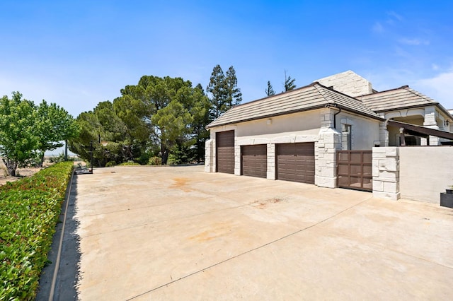 14215 Killarney Dr, Madera, CA 93636 - view of home's exterior with stone siding, stucco siding, and driveway