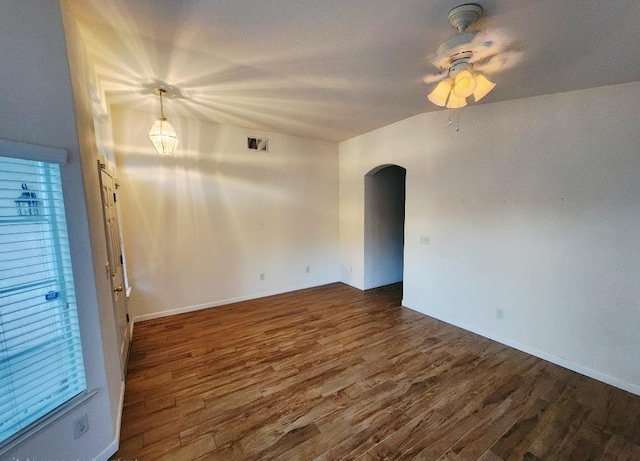 4686 W Sierra Ave, Fresno, CA 93722 - spare room featuring arched walkways, dark wood-type flooring, baseboards, and a ceiling fan