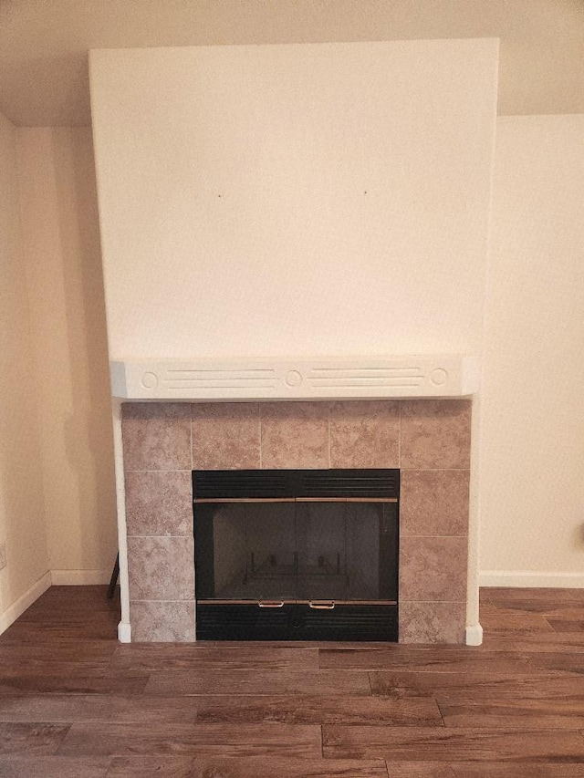 4686 W Sierra Ave, Fresno, CA 93722 - detailed view of a tiled fireplace, wood finished floors, and baseboards