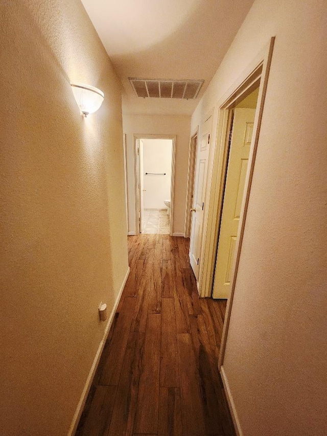 4686 W Sierra Ave, Fresno, CA 93722 - corridor featuring dark wood finished floors, baseboards, and a textured wall