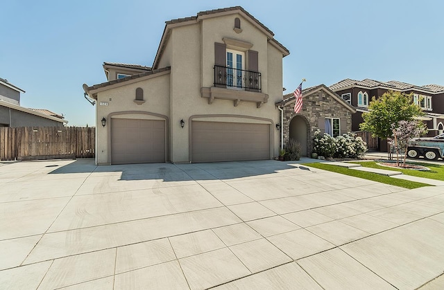 1523 N Ryan Ave, Clovis, CA 93619 - mediterranean / spanish-style home featuring a balcony, stucco siding, concrete driveway, an attached garage, and a tile roof