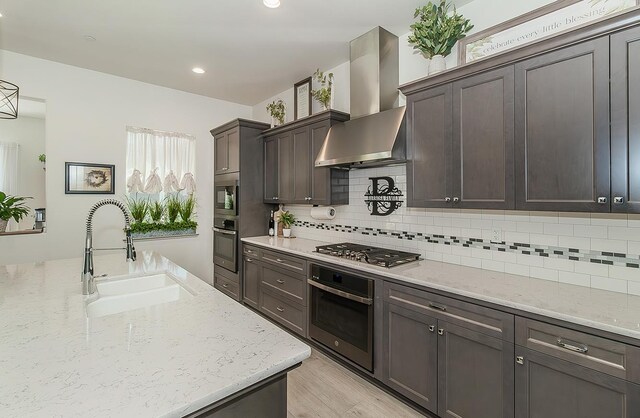 1523 N Ryan Ave, Clovis, CA 93619 - kitchen featuring stainless steel appliances, wall chimney range hood, a sink, decorative backsplash, and recessed lighting