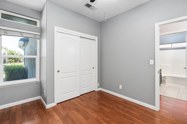 8574 N Heartland Way, Fresno, CA 93720 - unfurnished bedroom featuring multiple windows, wood finished floors, baseboards, and a closet