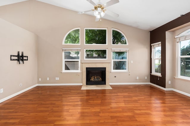 8574 N Heartland Way, Fresno, CA 93720 - unfurnished living room with wood finished floors, a ceiling fan, a tiled fireplace, vaulted ceiling, and baseboards