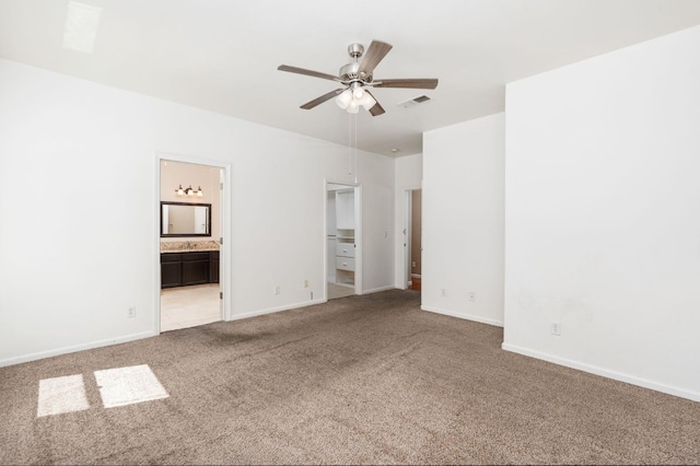 8574 N Heartland Way, Fresno, CA 93720 - unfurnished bedroom featuring light carpet, ensuite bathroom, baseboards, a spacious closet, and a ceiling fan