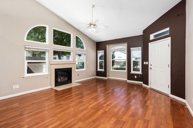 8574 N Heartland Way, Fresno, CA 93720 - unfurnished living room featuring ceiling fan, wood finished floors, high vaulted ceiling, a tile fireplace, and baseboards