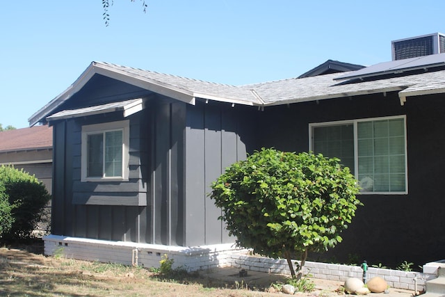 4657 E Hamilton Ave, Fresno, CA 93702 - view of side of property featuring board and batten siding, solar panels, and roof with shingles