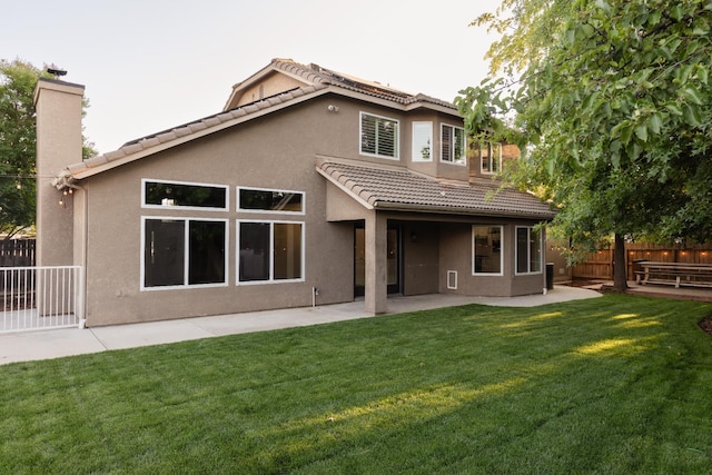2176 E Pinehurst Ave, Fresno, CA 93730 - back of house with a tile roof, stucco siding, a patio area, and a chimney