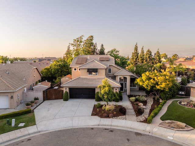 2176 E Pinehurst Ave, Fresno, CA 93730 - mediterranean / spanish home with a tiled roof, a gate, stucco siding, concrete driveway, and solar panels