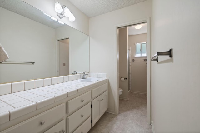 1709 W Calimyrna Ave Unit B, Fresno, CA 93711 - bathroom featuring toilet, vanity, a textured ceiling, and baseboards