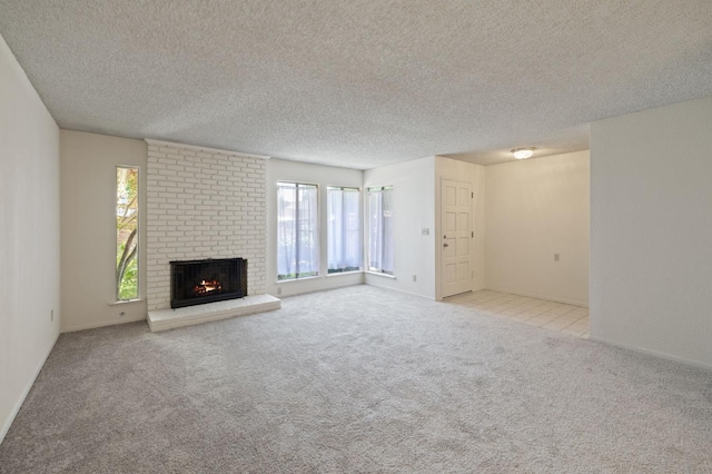 1709 W Calimyrna Ave Unit B, Fresno, CA 93711 - unfurnished living room featuring plenty of natural light, carpet, a brick fireplace, and a textured ceiling