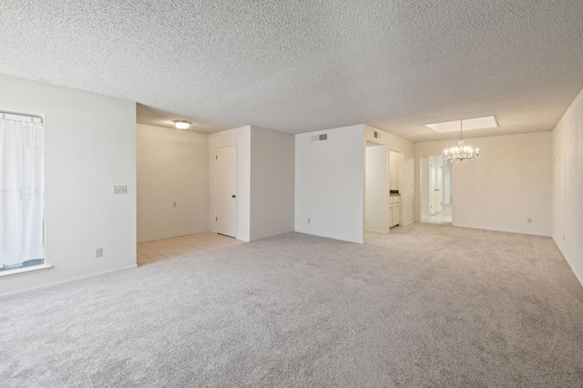 1709 W Calimyrna Ave Unit B, Fresno, CA 93711 - unfurnished room with a chandelier, light carpet, and a textured ceiling