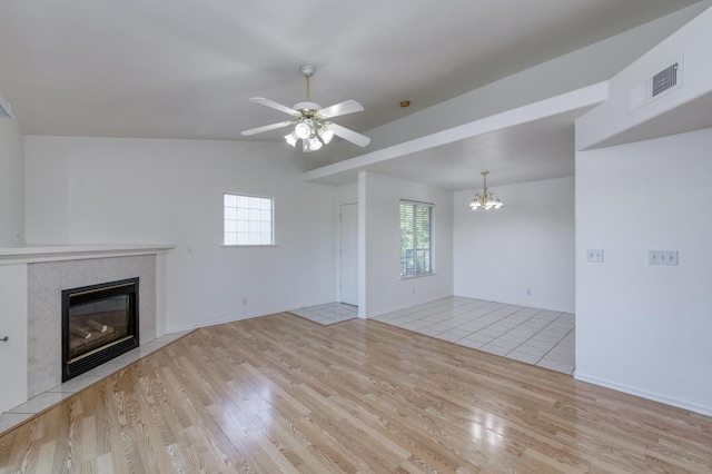 1542 E Alluvial Ave Unit 224, Fresno, CA 93720 - unfurnished living room featuring a tiled fireplace, a chandelier, light wood-style flooring, ceiling fan, and vaulted ceiling