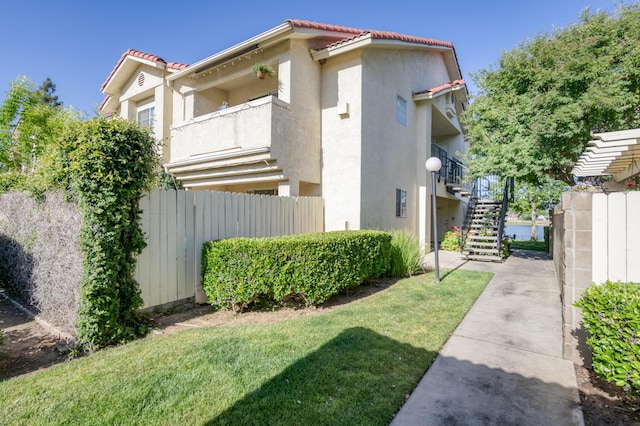 1542 E Alluvial Ave Unit 224, Fresno, CA 93720 - view of home's exterior featuring stairway, a tile roof, and stucco siding