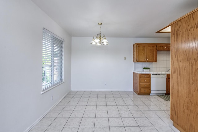 1542 E Alluvial Ave Unit 224, Fresno, CA 93720 - kitchen with white dishwasher, a chandelier, tile countertops, brown cabinetry, and tasteful backsplash