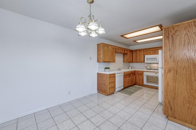 1542 E Alluvial Ave Unit 224, Fresno, CA 93720 - kitchen with white appliances, light countertops, a chandelier, decorative backsplash, and brown cabinetry