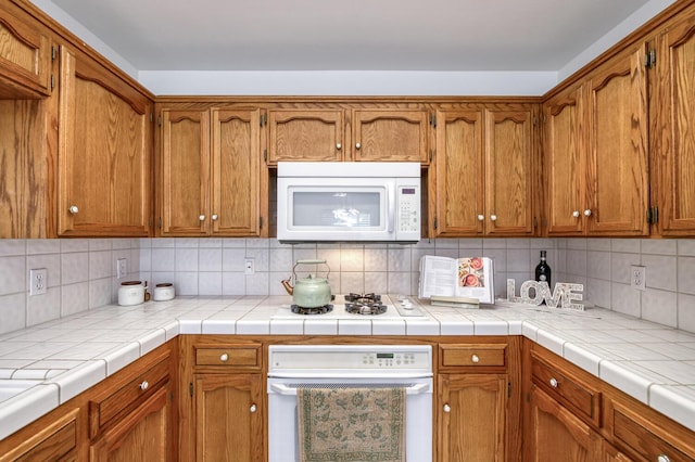 1542 E Alluvial Ave Unit 224, Fresno, CA 93720 - kitchen featuring white appliances, brown cabinetry, backsplash, and light countertops