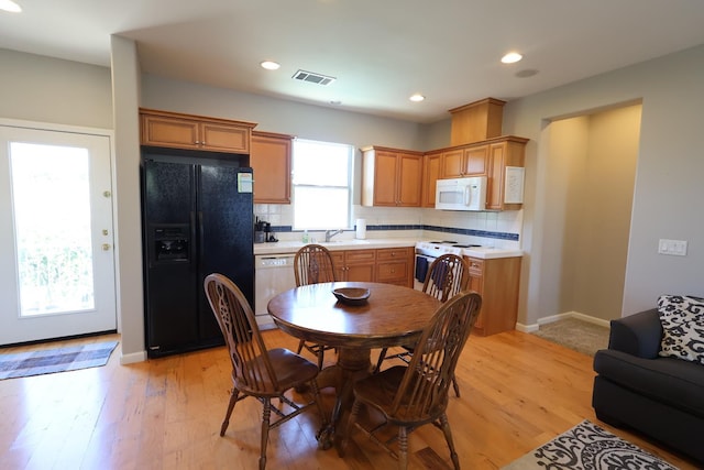 2143 Everglade Ave, Clovis, CA 93619 - kitchen with white appliances, decorative backsplash, light countertops, light wood-style floors, and baseboards