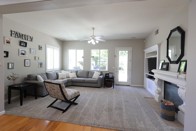 2143 Everglade Ave, Clovis, CA 93619 - living room featuring healthy amount of natural light, a fireplace with flush hearth, ceiling fan, and baseboards