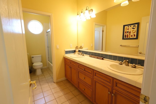 2143 Everglade Ave, Clovis, CA 93619 - bathroom with tile patterned floors, double vanity, toilet, and enclosed tub / shower combo