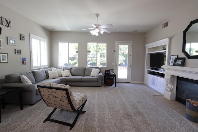 2143 Everglade Ave, Clovis, CA 93619 - living area featuring ceiling fan, a fireplace with flush hearth, and light colored carpet
