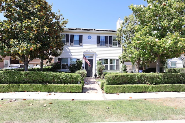 2143 Everglade Ave, Clovis, CA 93619 - view of front facade with a chimney, roof mounted solar panels, and a front lawn