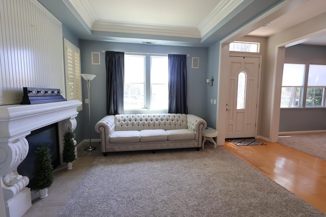 2143 Everglade Ave, Clovis, CA 93619 - living area with ornamental molding, a tray ceiling, baseboards, a glass covered fireplace, and light wood finished floors