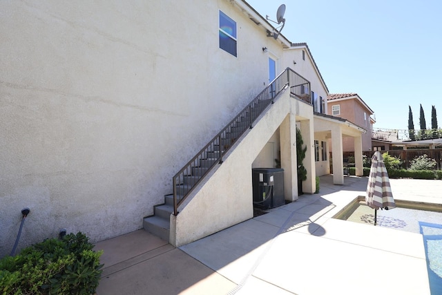 2143 Everglade Ave, Clovis, CA 93619 - view of home's exterior featuring stairway, stucco siding, a patio, and central AC unit