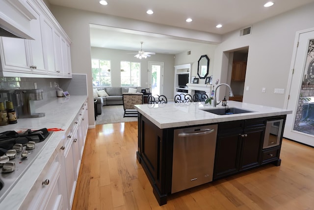 2143 Everglade Ave, Clovis, CA 93619 - kitchen with a sink, stainless steel appliances, white cabinetry, light wood-style floors, and an island with sink