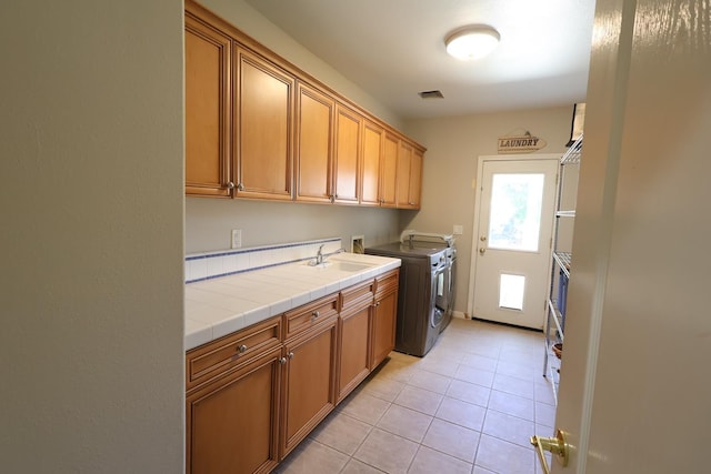 2143 Everglade Ave, Clovis, CA 93619 - laundry room with cabinet space, light tile patterned flooring, and washer and clothes dryer