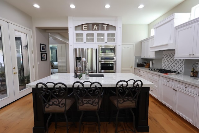 2143 Everglade Ave, Clovis, CA 93619 - kitchen with appliances with stainless steel finishes, light stone counters, tasteful backsplash, a kitchen bar, and recessed lighting