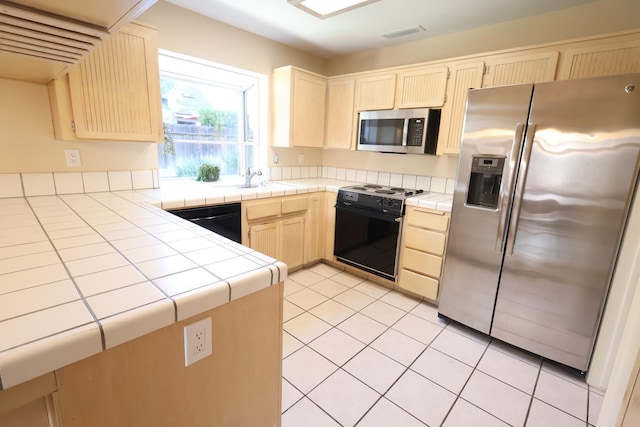 1866 E Goshen Ave, Fresno, CA 93720 - kitchen with black appliances, tile countertops, light brown cabinetry, a sink, and light tile patterned floors