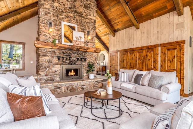 55606 Rd 226, North Fork, CA 93643 - living area featuring wooden ceiling with exposed beams, high vaulted ceiling, a stone fireplace, and wooden walls