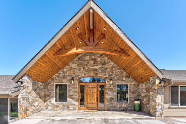 55606 Rd 226, North Fork, CA 93643 - view of front of house featuring stone siding, roof with shingles, and a patio area